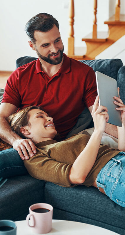Ein Paar informiert sich am Tablet über die zahlreichen Kreditangebote von SMART24HRS.COM.